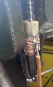 Soldered copper wire attached to conductive metal coating on PEEK polymer demonstrating electrical connectivity