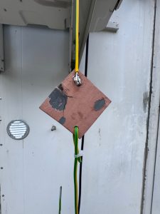 Mechanical load test of conductive polymer coating on PEEK showing 10 kg suspended weight without delamination